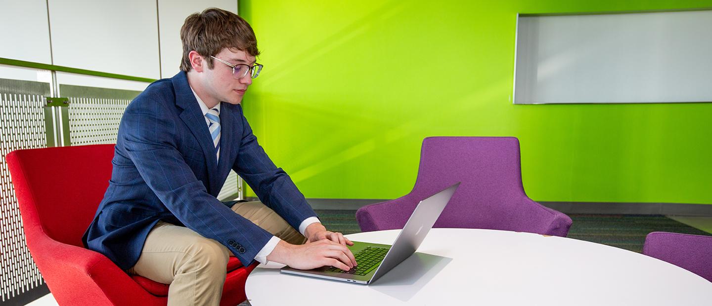 A young man using a laptop at a work table